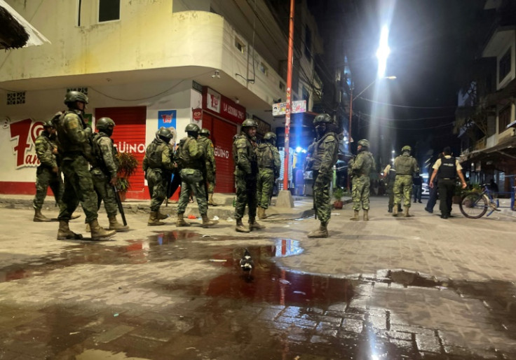 Military and police officers guard a restaurant where an armed group shot at customers and workers in Montanita, Ecuador