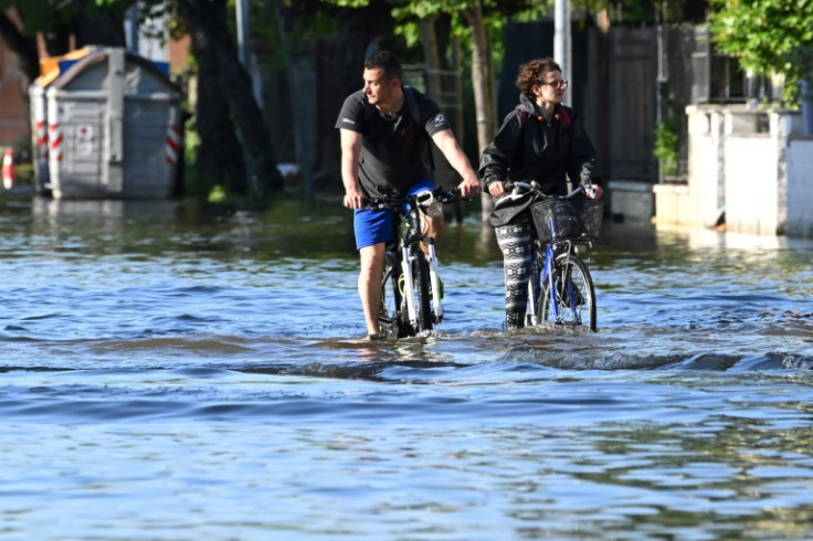 Residents ride their bicycle across a flooded street on May 21, 2023 in Conselice, near Ravenna