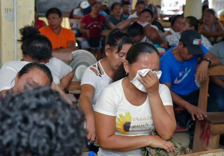 Relatives of the school dormitory fire sob during a meeting with Guyana President Irfaan Ali in Mahdia, where the tragedy happened