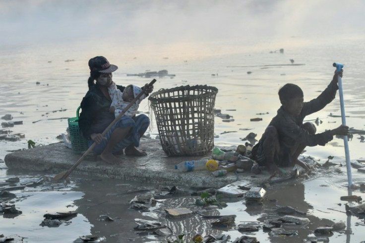 Waste collectors looking for plastic and glass to recycle in Pazundaung Creek, Yangon