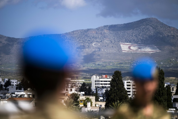 UN peacekeepers in the buffer zone in the divided capital of Nicosia. In the distance, the flag of the self-proclaimed Turkish Republic of Northern Cyprus is seen on the island's northern Kyrenia mountain range