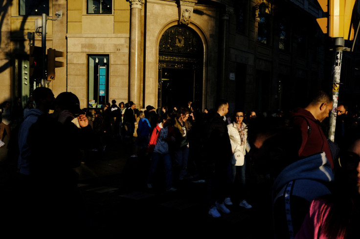 Tourists and locals walk at at Placa de Catalunya in Barcelona