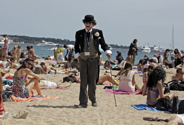 A man dressed as Charlie Chaplin walks on the beach in Cannes during the 65th Cannes Film Festival
