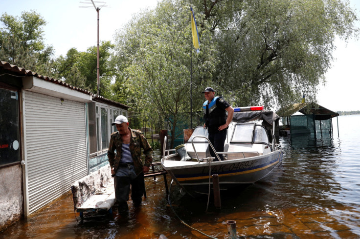 Mykola stands next to a police boat on a flooded island which locals and officials say is caused by Russia's chaotic control of the Kakhovka dam downstream, near Zaporizhzhia