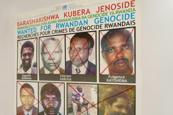 Kayishema's face, top right, is crossed out on a wanted poster Friday at the Genocide Fugitive Tracking Unit in Kigali, Rwanda