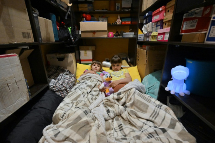 Children shelter in a boxroom from Russian strikes on Kyiv, May 2023