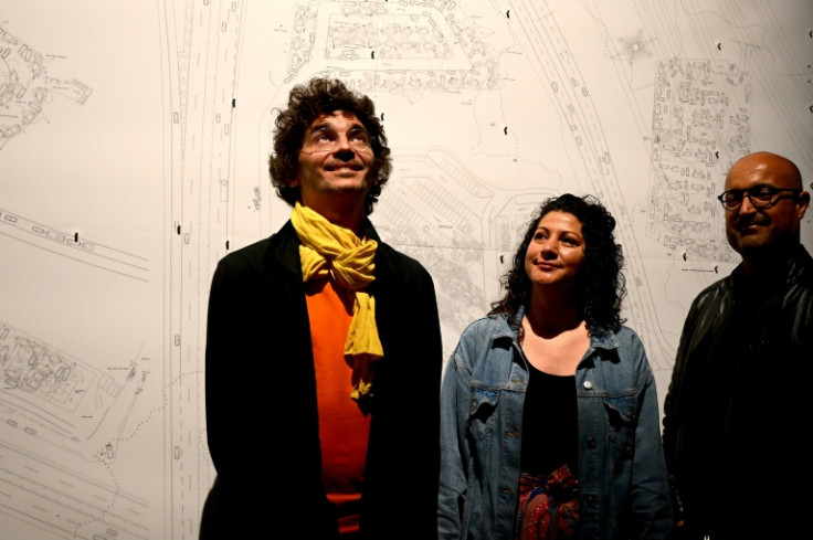 Mounir Ayoub, left, a 40-year-old Tunisian architect at the exhibition at Venice's former shipyards