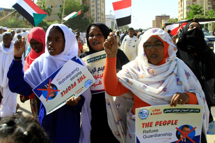 Protesters carry crossed-out pictures of the UN's special envoy Volker Perthes during a demonstration in Khartoum on December 3, 2022