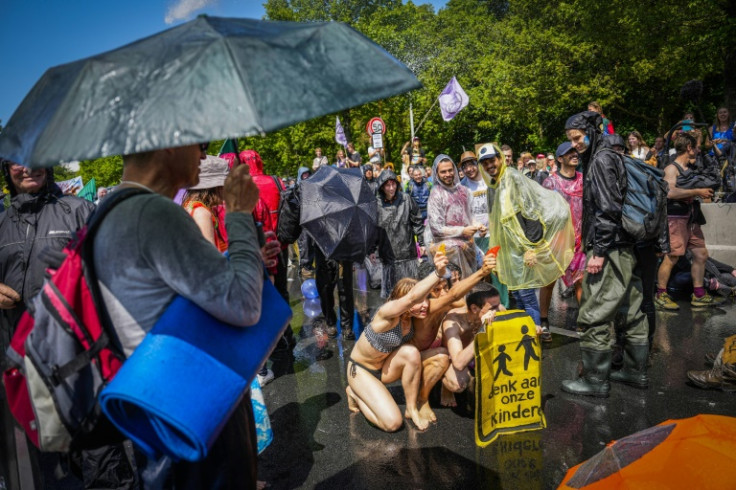 Some wore swimsuits or carried umbrellas as they sat in protest across the A12 motorway, holding banners and signs