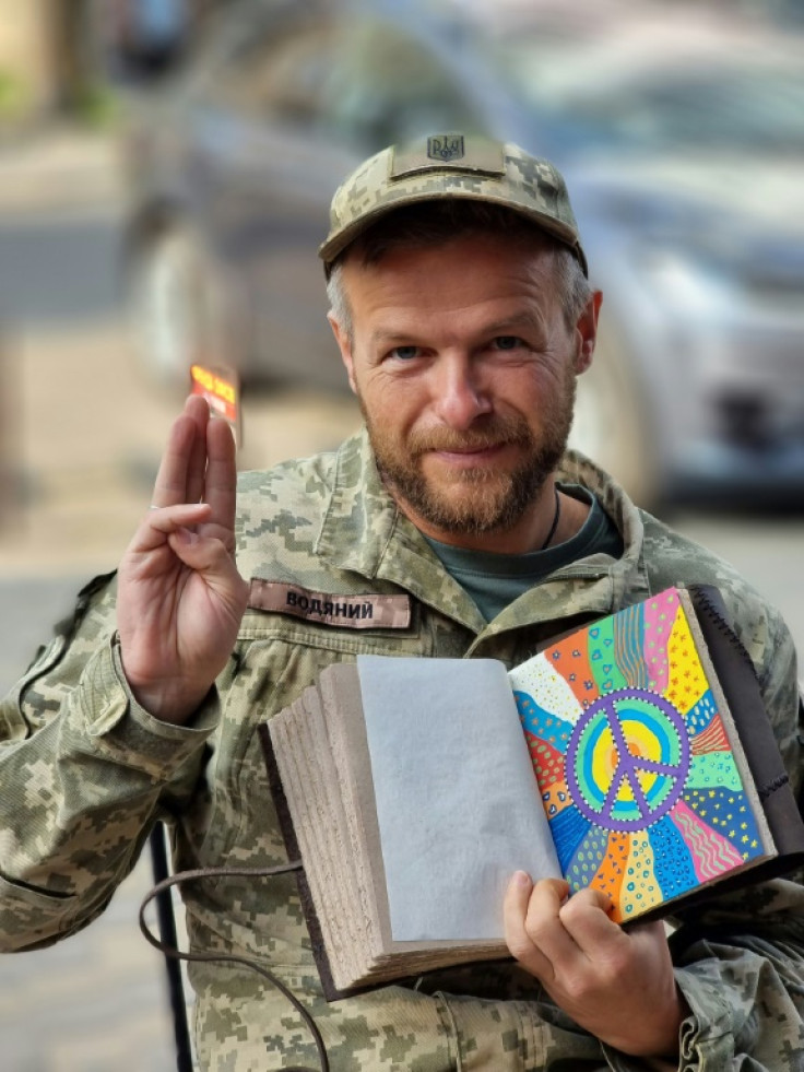Writer Artem Chapeye, an active duty serviceman in the Ukrainian armed forces, poses for a photo at an undisclosed location near a military barracks