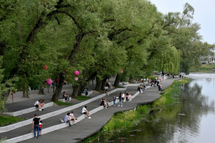 People walk along the Vezelka riverand in parks enjoying the sun