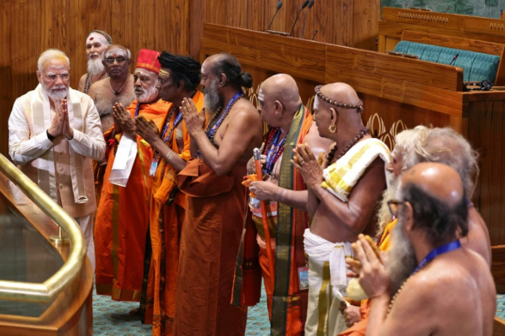 India's Prime Minister Narendra Modi (L) gestures to priests during the inauguration ceremony of the new parliament building in New Delhi