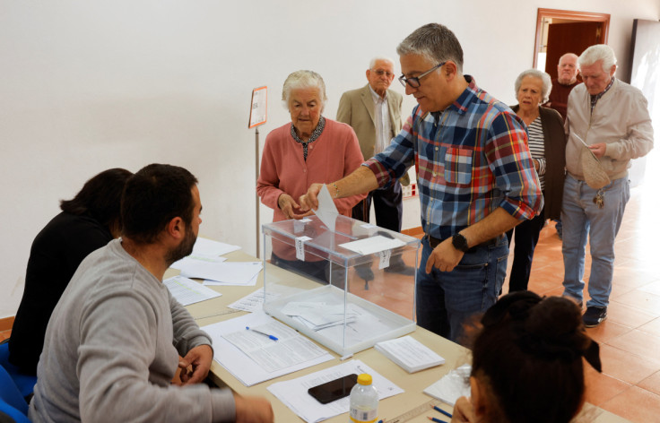 A man helps his mother to cast her vote at a polling station during local elections, in Ronda