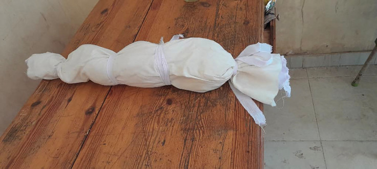 Baby's body lies wrapped in white material in Khartoum
