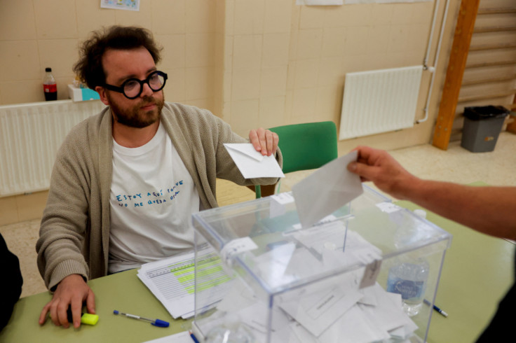 The president of an electoral table wears a shirt with a protest message during the local elections, in Ronda