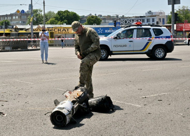 A police expert examines fragments of a downed missile after Russia fired a barrage at Kyiv for the second time in 24 hours