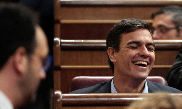 Former leader of PSOE Sanchez laughs in front of Socialists parliamentarian spokesman Hernando during the investiture debate at Parliament in Madrid