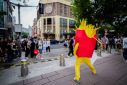 Person dressed as a chips mascot stands in a market on a street in Shanghai