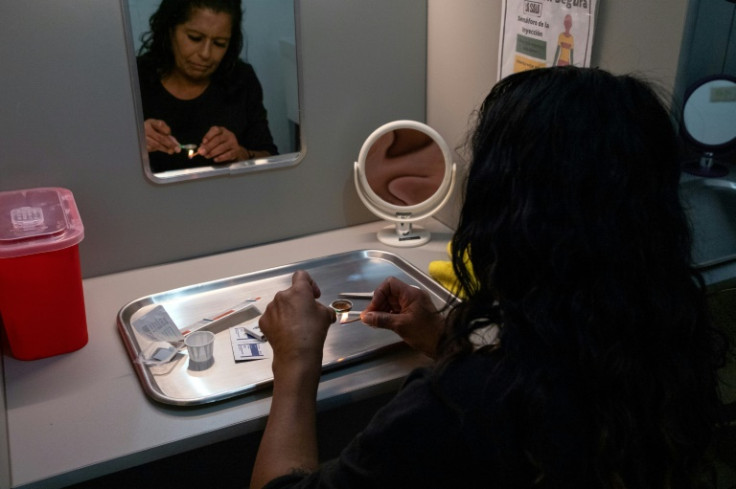 Elena Ruelas prepares heroin to inject at a safe-use space in Mexicali, northern Mexico