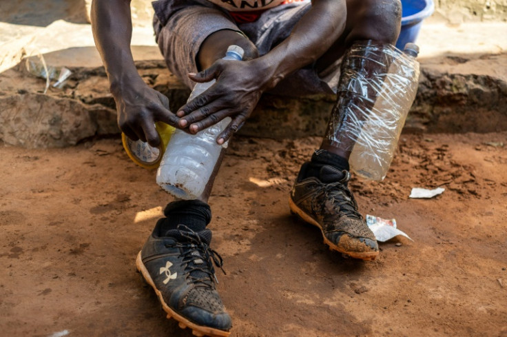 Kasumba uses water-filled plastic bottles taped to his legs for resistance