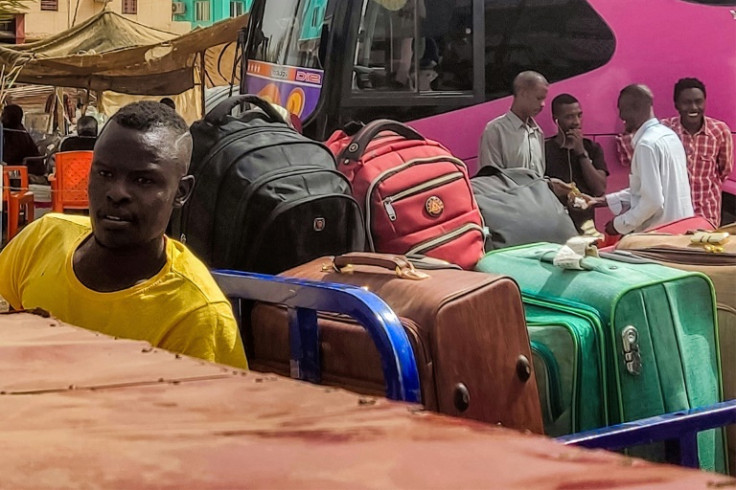 Sudanese people fleeing the violence prepare to depart on buses from al-Sittin road in the south of Khartoum on May 30, 2023