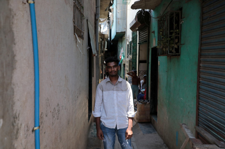 Nizamudin Abdul Rahim Khan poses for a photograph in an alley at a slum area in Mumbai