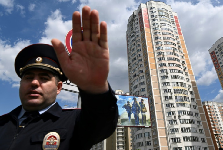 A police officer secures an area outside a damaged block after the attack in which two people were slightly hurt