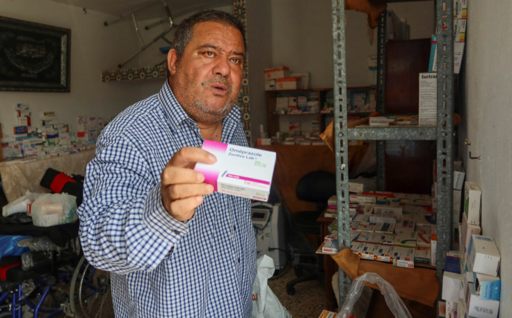 Retired soldier Nabil Boukhili, who has opened an unofficial medicine exchange for his neighbourhood from the roof of his Tunis house, holds a box of medicine in Tunis