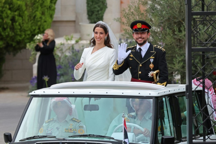 Jordan's Crown Prince Hussein and his Saudi wife Rajwa Al Seif wave as they leave the Zahran Palace in Amman