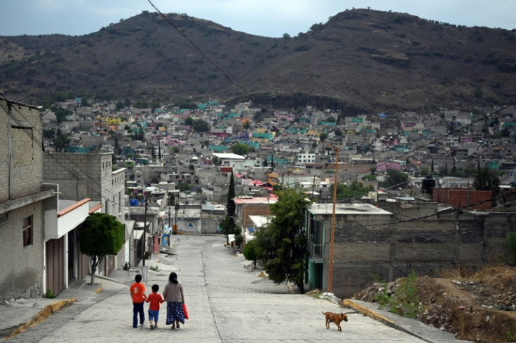 A family walks down a street in a neighborhood of Mexico's most populous state, which is preparing to elect a new governor