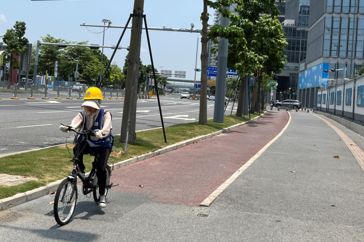 A cyclist rides in the sun amid a yellow alert for heatwave in Shenzhen