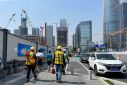 Construction workers walk in the sun amid a yellow alert for heatwave in Shenzhen