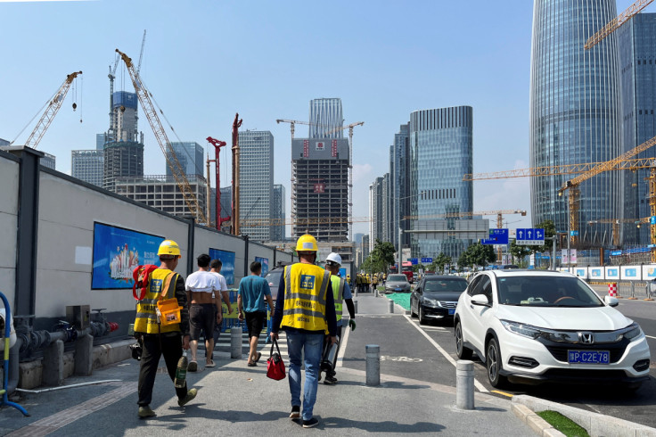 Construction workers walk in the sun amid a yellow alert for heatwave in Shenzhen