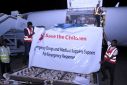 People unload boxes containing medical aid off a plane from Kenya at the military airport in Port Sudan