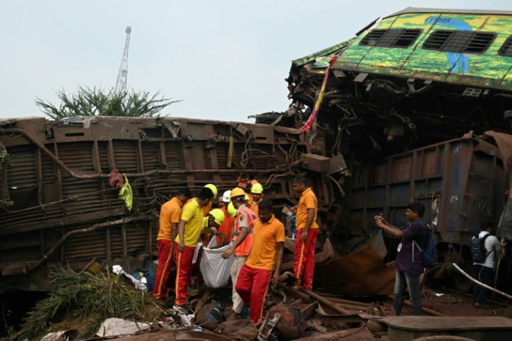 Rescue workers carry the body of a victim recovered from the train crash wreckage