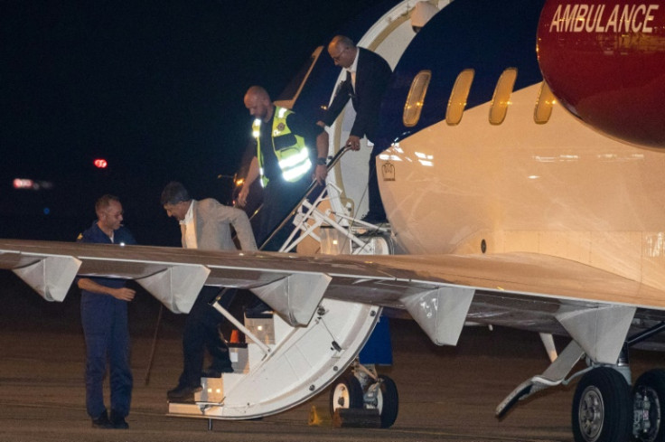 Austrian-Iranian citizens Massud Mossaheb (2nd l) and Kamran Ghaderi step off a plane upon arrival at Melsbroek military airport in Belgium following their release from Iran