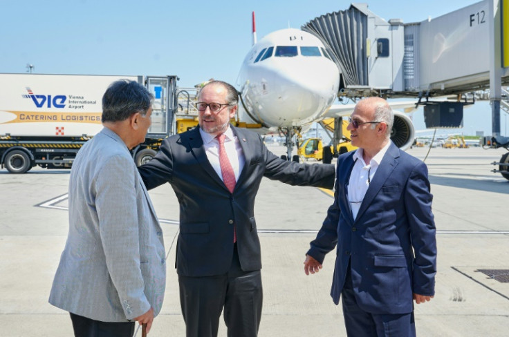 Austrian foreign minister Alexander Schallenberg (c) greets Massud Mossaheb (l) and amran Ghaderi at the Vienna airport in Schwechat