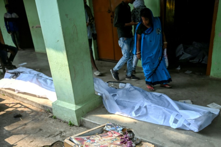 A woman looks at the body of a relative at a makeshift morgue set up in a high school in eastern India after the country's worst train disaster in decades killed 288 people