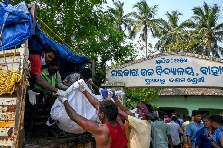 Rescuers load the body of a victim onto a truck at a makeshift morgue set up in a school after India's worst train disaster in decades killed 288 people