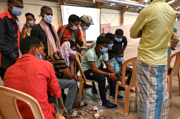 Family members look at photographs to identify bodies at a temporary morgue after a train disaster in the eastern state of Odisha killed at least 288 people