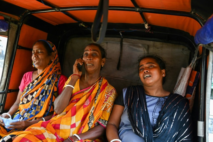 Grieving familiy members wait to identify loved ones at a temporary morgue after a train disaster in the eastern Indian state of Odisha killed at least 288 people