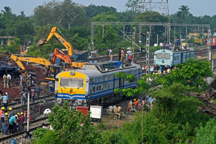 Police and workers inspect damaged carriages and tracks after a train disaster in the eastern state of Odisha killed at least 288 people
