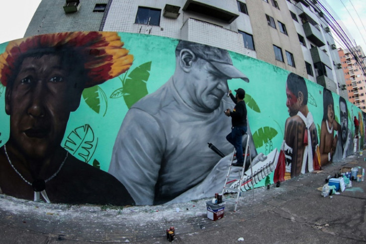 Brazilian artist And Santtos works on a large  mural honoring British journalist Dom Phillips and Brazilian Indigenous affairs expert Bruno Pereira, in Belem, Para State, Brazil, on July 31, 2022