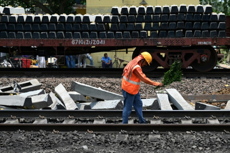 A worker inspects the newly restored track at the site of Friday's train disaster that killed at least 275 people in the eastern state of Odisha