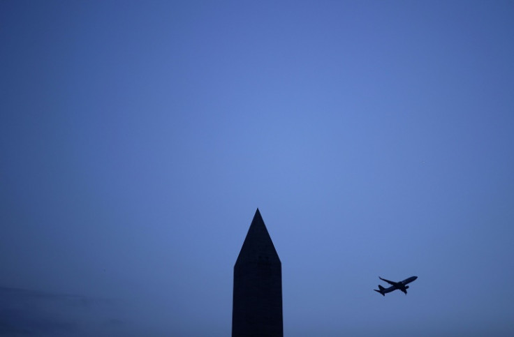 A plane flies behind the Washington Monument on the US National Mall in December 2016