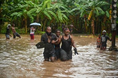 Residents wade through flooded roads in neighborhoods of Petit-Goave, Haiti in June 3, 2023, during heavy rainfall