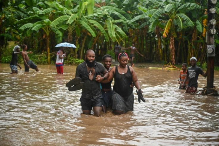 Residents wade through flooded roads in neighborhoods of Petit-Goave, Haiti in June 3, 2023, during heavy rainfall