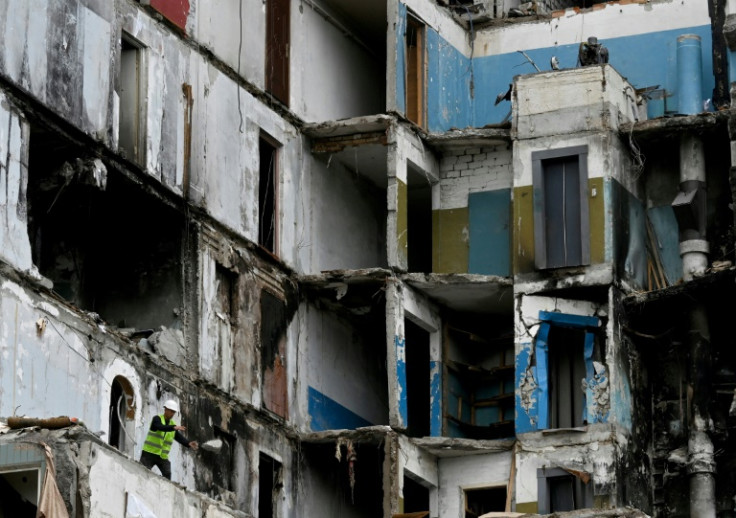 A worker clears debris in a partially destroyed residential building after a Russian missile strike on April 28, 2023, in Uman