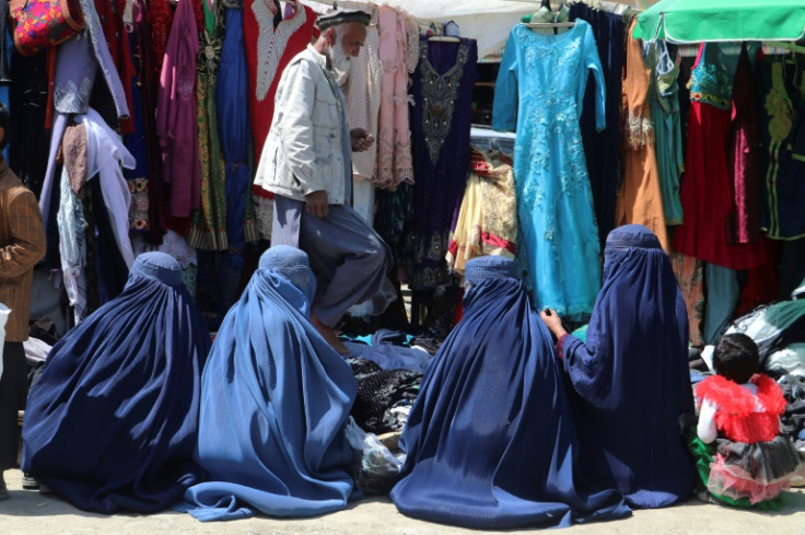 Afghan women sift through clothes for sale at a market in Argo district of Badakhshan province
