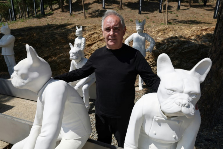 Spanish chef Ferran Adria poses next to sculptures he calls "Bullinanos" outside the elBulli restaurant which is set to reopen as a museum